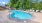 a swimming pool with trees and a fence around it