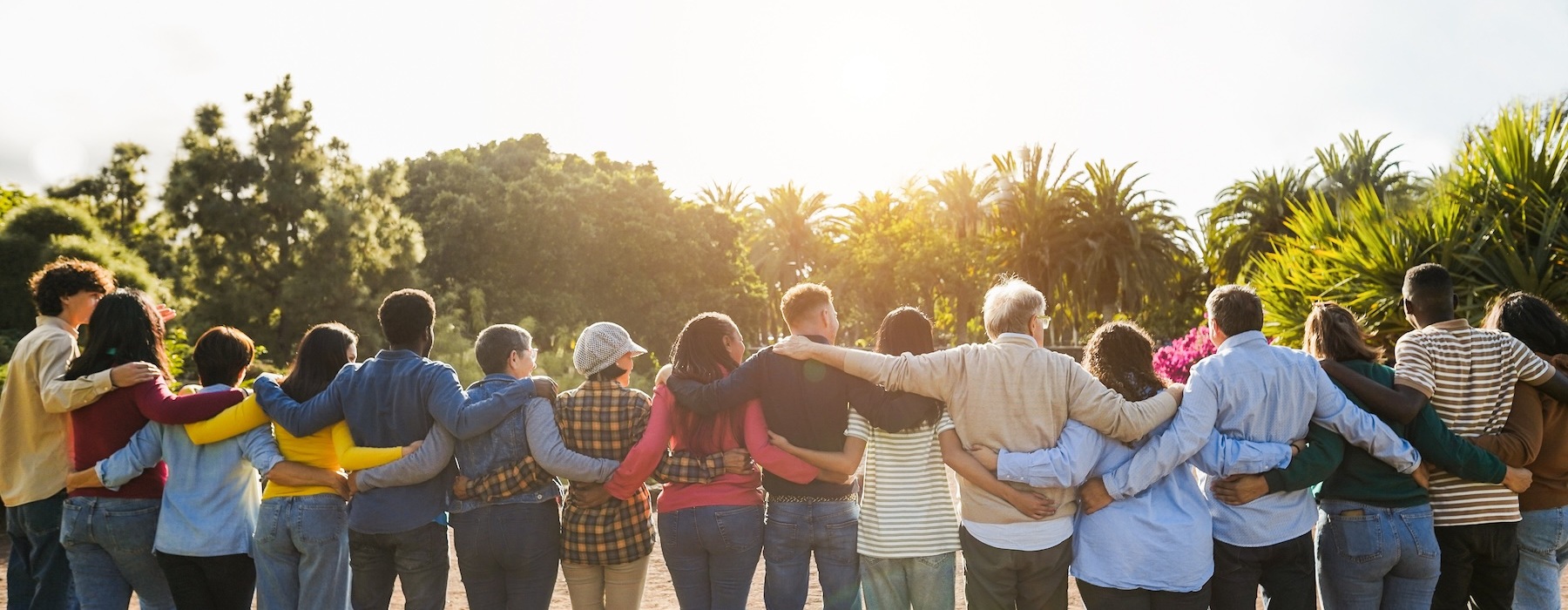 a group of people embracing looking at a sunset
